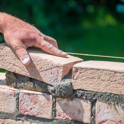 Masonry Tools | Craftsman Supply Co. (hand of a masonry worker laying brick)