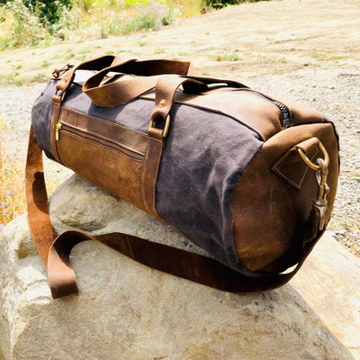 Handcrafted Goods | Craftsman Supply Co. (image of a handcrafted canvas and leather bag sitting on a rock with a scenic outdoor background)